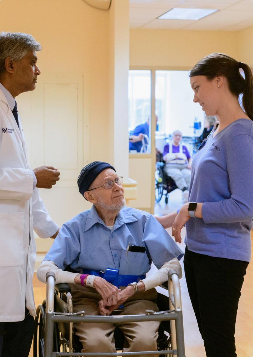 Patient in wheelchair speaking with staff